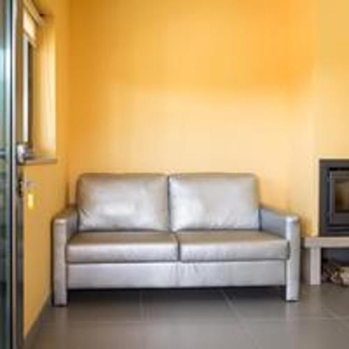a couch sitting in a living room next to a fireplace at Comfortable Bungalow Pinhel, pool in Pinhel