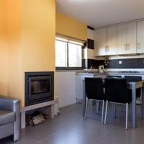 a kitchen with a table and chairs and a tv at Comfortable Bungalow Pinhel, pool in Pinhel