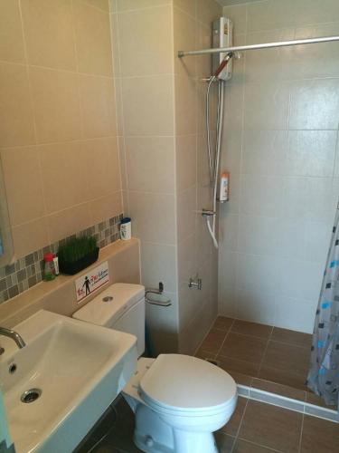 a bathroom with a toilet and a sink and a shower at Bann Imm Aem Condo No.376 in Hua Hin