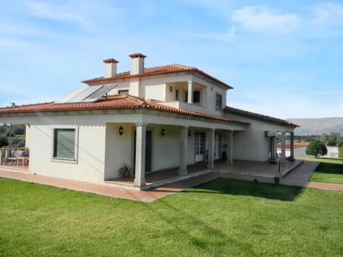 a white house with a large yard at Welcoming villa in Santa Leocádia, private pool 475 m² in Feijoal