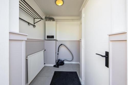 a hallway with a hose on the wall in a building at Strandhuys Oester in De Koog