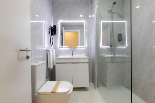 a bathroom with a shower and a toilet and a sink at Gaivota Guest House in Ponta Delgada
