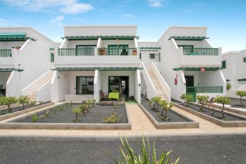 a large white building with a courtyard in front at Charming apartment in Tías with shared pool - 50 m² in Tías