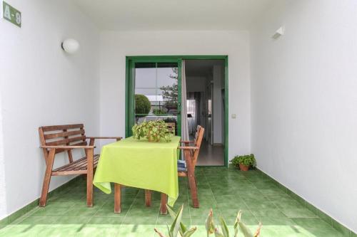 a dining room table with a green table cloth and chairs at Charming apartment in Tías with shared pool - 50 m² in Tías