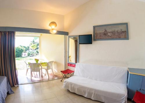 a living room with a couch and a table with chairs at Studio confortable à Sainte-Anne - 30 m² avec vue mer in Sainte-Anne