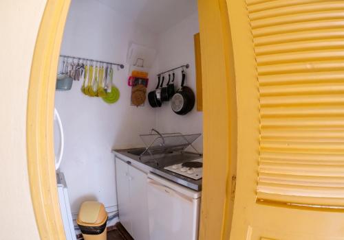 a kitchen with a stove top oven in a room at Studio confortable à Sainte-Anne - 30 m² avec vue mer in Sainte-Anne