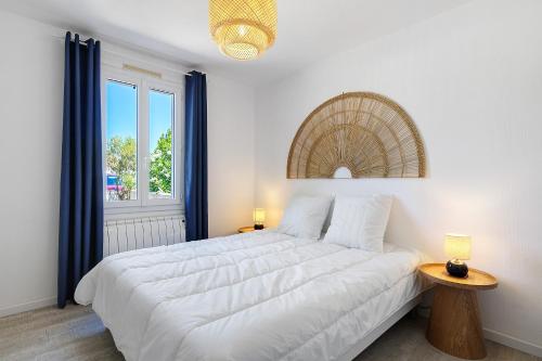 a bedroom with a large white bed and a window at L'Epine Bleue in LʼÉpine