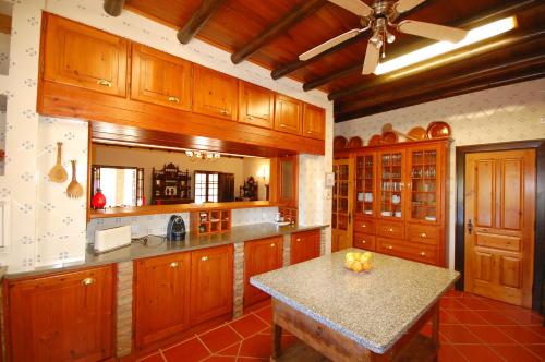 a large kitchen with wooden cabinets and a table at Rustic Villa Tavira with Mountain Views and Pool in Tavira