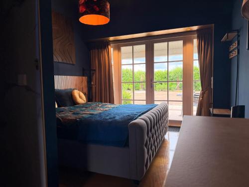 a bedroom with a bed and a sliding glass door at De Hombrake, Bed & Breakfast in Wilp