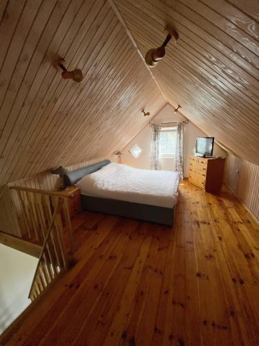 a bedroom with a bed in a wooden ceiling at Authentic Fisherman House in Preila