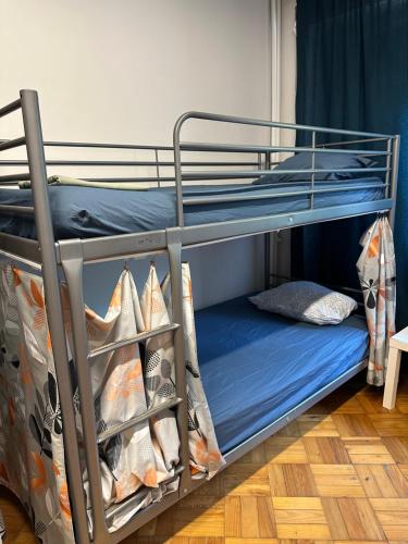 a bunk bed with blue sheets and a blue mattress at ICOSIUM Hostel in Braga