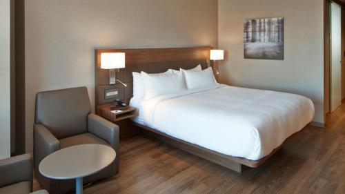 a hotel room with a large bed and a chair at AC Hotel by Marriott Minneapolis Downtown in Minneapolis