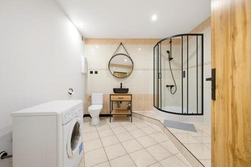 a bathroom with a shower and a washing machine at Apartamenty Centrum in Rybnik