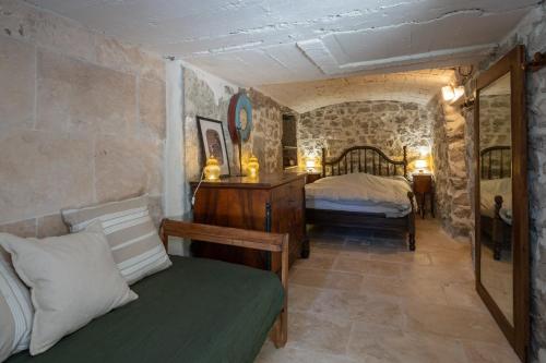 a bedroom with a bed in a stone room at Maison Henriette - Authentique maison ardéchoise in Labeaume
