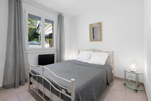 a bedroom with a bed and a window at Villa Hacienda piscine et terrasse in Vidauban