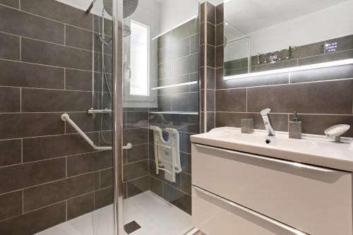 a bathroom with a sink and a glass shower at Villa Hacienda piscine et terrasse in Vidauban