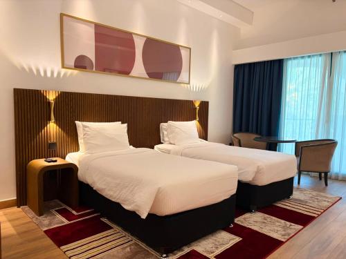 a hotel room with two beds and a table at Arabian Palace Hotel in Al Rahba