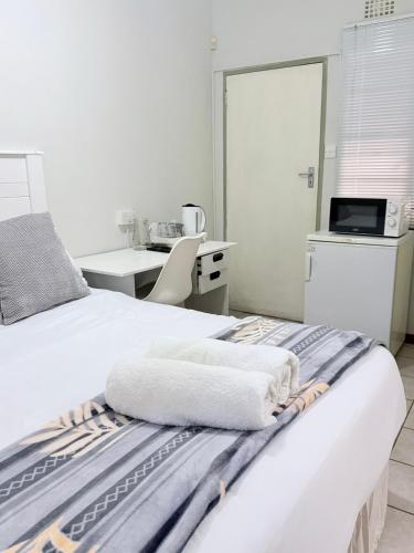 a bedroom with a bed with two towels on it at Paradise Corner in Francistown