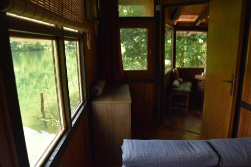 a room with a bed and windows in a train at ECO cabin Plivsko jezero Jajce in Jajce