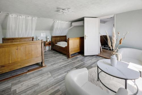 a living room with a bed and a table at Gite grande capacité en Puisaye in Breteau