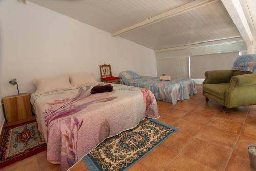 a bedroom with a bed and a chair at Barnhouse Duplex in Idanha-a-Nova