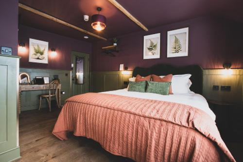 a bedroom with a large bed and a desk at The Linen Rooms in Knutsford