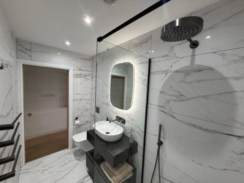 a white bathroom with a sink and a mirror at Auberge Hotel by Sasco in Lytham St Annes