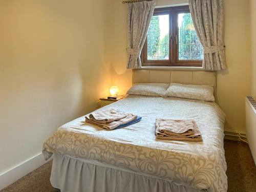 a bedroom with a bed with two towels on it at Bramble Grange in Derby