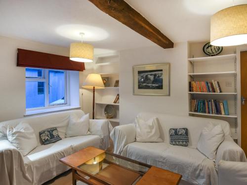 a living room with two white couches and a table at Sheldon Cottage in Bishops Castle