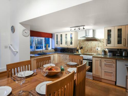 a kitchen with a wooden table with chairs and a dining room at Sheldon Cottage in Bishops Castle
