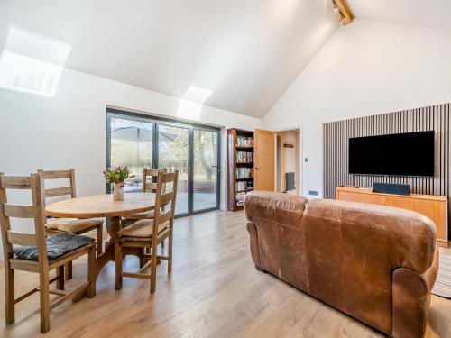 a living room with a couch and a table at Maple Barn in Eye
