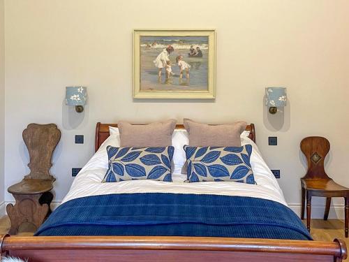 a bedroom with a bed with a painting on the wall at Maple Barn in Eye
