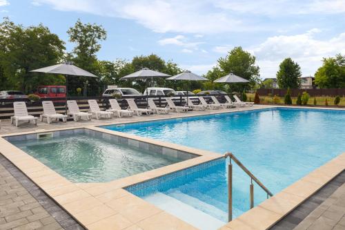 a large swimming pool with chairs and umbrellas at ROMANTIK in Solotvyno
