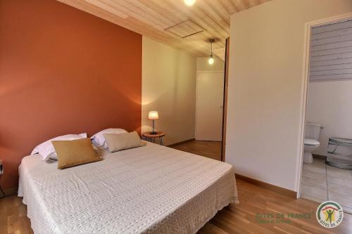 a bedroom with a white bed in a room at La maison des charretiers in Cohiniac