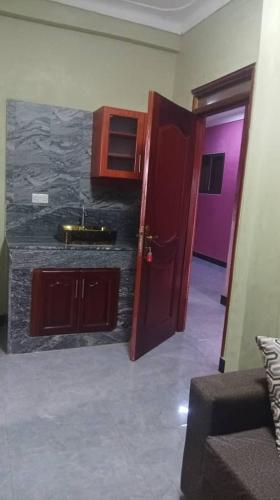 a bathroom with a sink and a door to a room at Rasaf Cottages and Intent suits in Kyebando