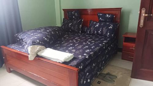 a bedroom with a bed with a purple comforter at Rasaf Cottages and Intent suits in Kyebando