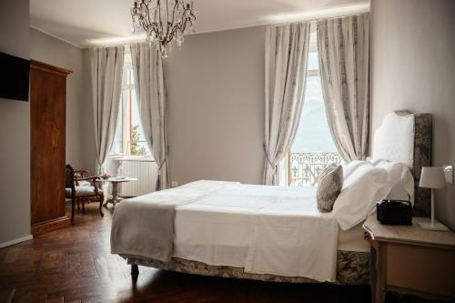 a bedroom with a large white bed with a window at Ca Meison in Cannobio