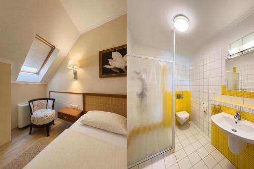 a bedroom with a bed and a bathroom with a sink at Mizse Motel in Lajosmizse