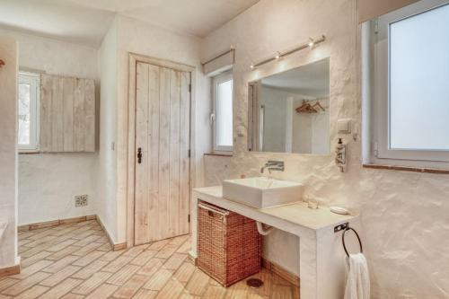 a white bathroom with a sink and a mirror at Casa do Sobreiro in Alcácer do Sal