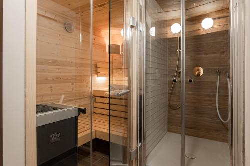 a shower in a bathroom with wooden walls at Gasthof Krone in Kinding