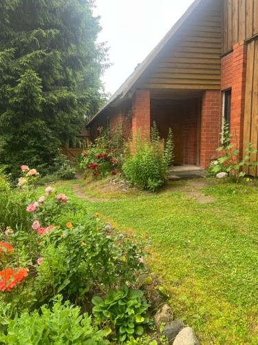 a garden in front of a house with flowers at Namiņš Brīviņi in Jaunjelgava