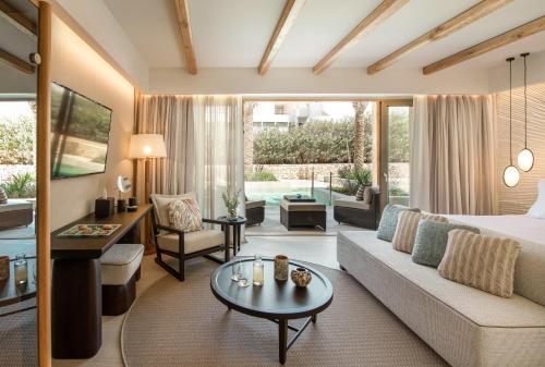 a hotel room with a bed and a living room at Mitsis Selection Rinela in Kokkini Khanion