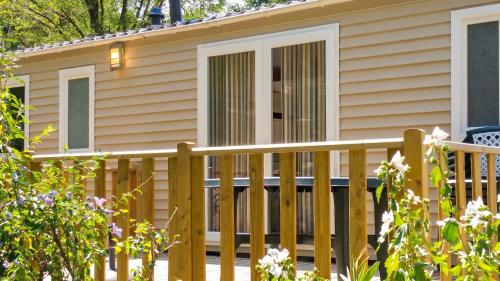 a house with a wooden fence in front of it at Chalet charmant à Saint-Jean-du-Gard in Saint-Jean-du-Gard