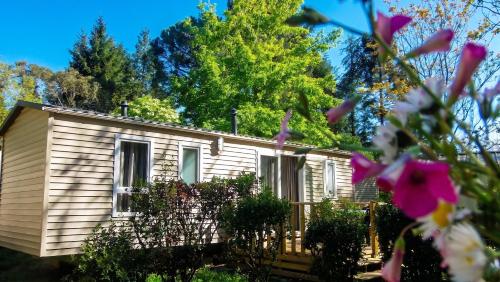a house with a fence and flowers in the foreground at Chalet charmant à Saint-Jean-du-Gard in Saint-Jean-du-Gard