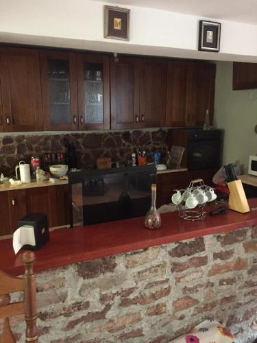 a kitchen with wooden cabinets and a counter with pots and pans at Spacious and Charming House in Vozuća with Large Garden in Vozuća