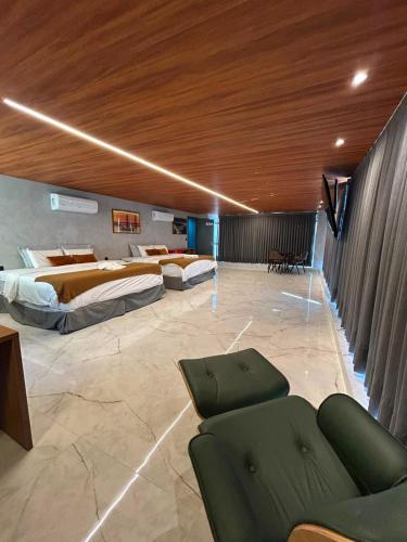 a hotel room with two beds and a couch at HOTEL NOVO CENTRO in Petrolina