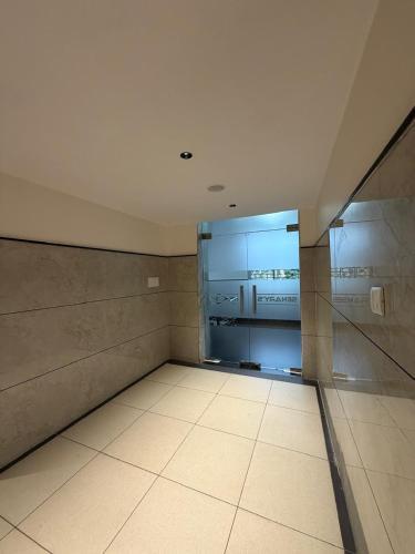 an empty room with a refrigerator in a building at Senary's Nest INN in Kyātsandra