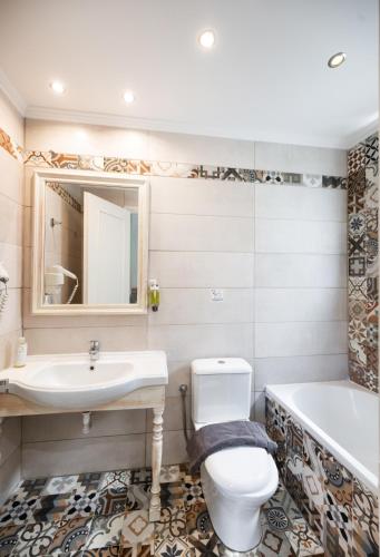 a bathroom with a sink and a toilet and a tub at Villaggio Maistro in Lefkada