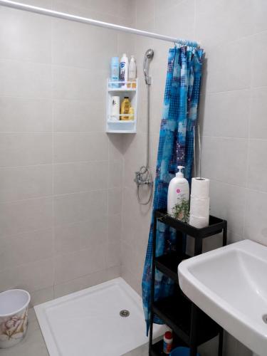 a bathroom with a shower curtain and a sink at Panoramic View, Cozy apartment M'diq in M'diq