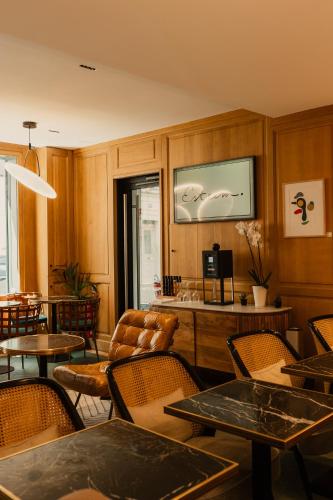 a restaurant with tables and chairs and a tv at Esteem Tour Eiffel in Paris